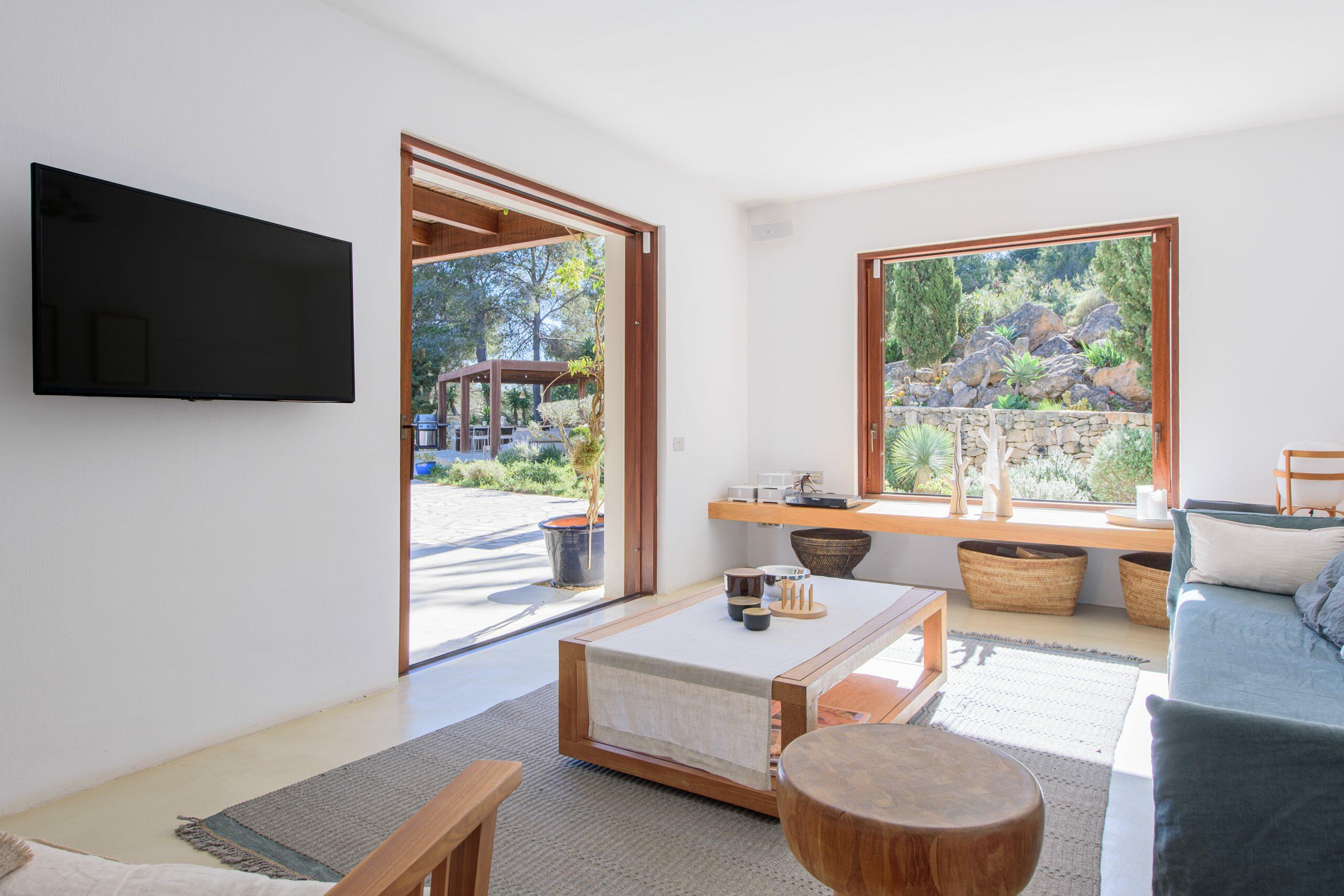 Bright living room in an Ibiza home with large openings to the garden and natural light.